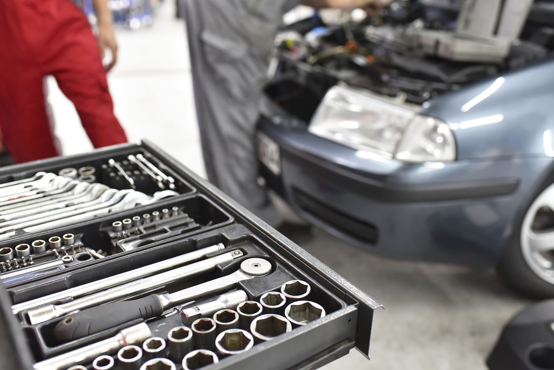 mechanic's garage, with a car undergoing repair and a toolbox in the foreground
